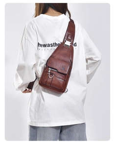 Brown faux leather chest bag showing metallic zippers and functional pockets on a model