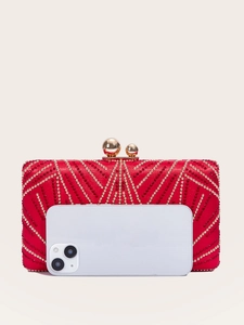 Detail of red and gold rhinestone evening bag with luxury clasp and smartphone for scale