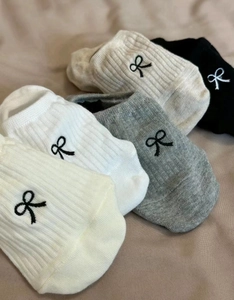 Detail of five pairs of ribbed low-cut socks with cute bow embroidery in various colors