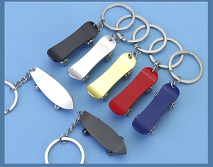 Various colors of mini metal skateboard keychains with wheels on blue background