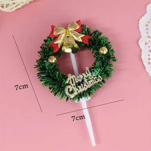 Detail view of a 7cm Christmas wreath cake topper with red bow and gold bells
