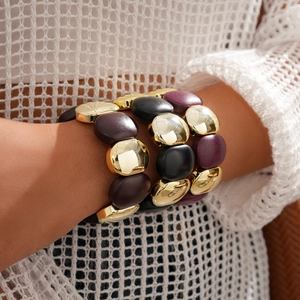 Gros plan de bracelets bohèmes extensibles avec perles dorées et résine mate