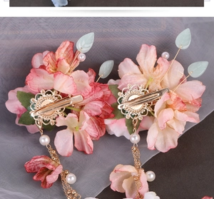 Close-up of pink silk flower hair clips with golden tassels and pearls for Hanfu style