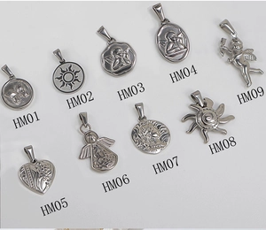 Flat lay of nine silver stainless steel pendants with butterfly and angel relief patterns