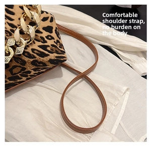 Close-up of leopard print bag with gold metal chain and brown leather shoulder strap
