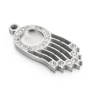 Silver metal Hamsa pendant with zircon stones and round setting on white background