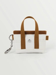 Dettaglio della mini borsa in tela con bottone a pressione in metallo e portachiavi