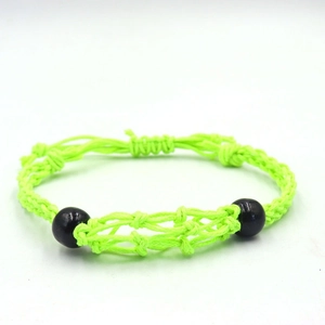 Detail of neon green woven cord bracelet with black beads and adjustable knot design
