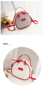 Detailed view of round lychee texture crossbody bag with 3D cherry and red accents