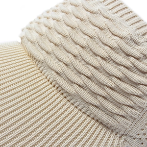 Macro detail of beige sun visor hat showing premium elastic ribbed knit texture and fabric