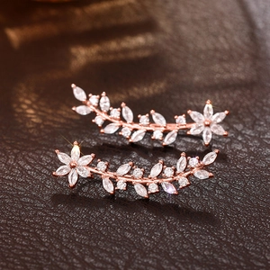 Macro view of crystal flower earrings with rose gold vines and sparkling cubic zirconia