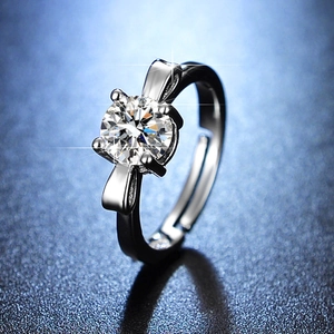 Detail of four-prong silver ring with a bow-knot design and adjustable open band