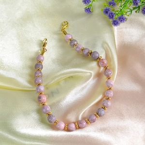 Detail of 8mm pink zebra stone beads with gold spacers and lobster clasp on silk