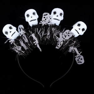 Halloween headband with four glowing white skulls and black and white tassels on a black frame