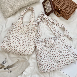 Detail view of floral canvas tote bags with bow-tie shoulder strap