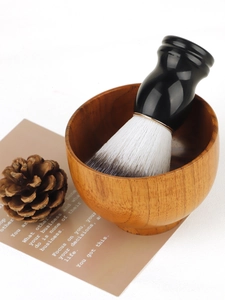 Detailopname van een klassieke scheerkwast met zachte haren en een natuurlijke houten scheerkom