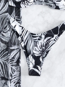 Detail of black and white tropical leaf print bikini bottom with matching mesh cover-up