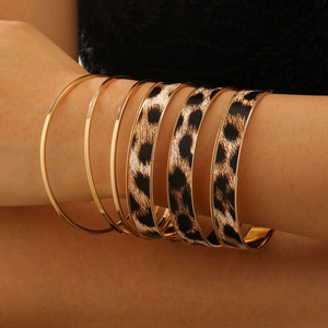 Detail shot of multi-layer gold alloy bangles featuring vintage leopard print patterns