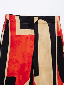 Close-up of abstract print pants showing waistband and pocket detail in black and red