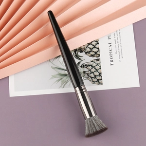 Chic angled contour brush with grey-white bristles and sleek black handle in modern setting