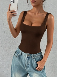Detail of a slim-fit brown square-neck sleeveless bodysuit paired with blue denim jeans