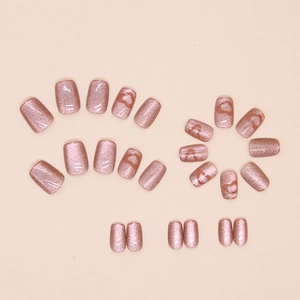 Detail of short cat-eye press-on nails in dusty rose with heart designs and 24 piece set