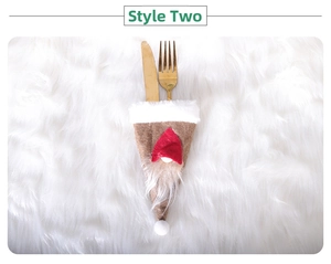 Close-up of gnome Christmas cutlery holder with gold knife and fork on plush background