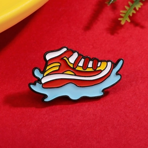 Broche créative en émail basket-ball rouge avec base bleue sur un fond rouge texturé