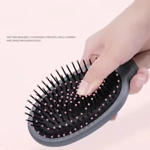 Gray ergonomic massage hairbrush with flexible air cushion and pink tipped bristles