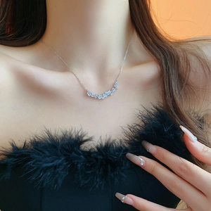 Close-up of elegant silver necklace with teardrop zircon pendant on female neck
