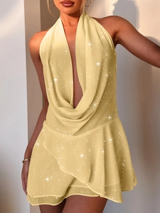 Macro detail of elegant yellow halter dress featuring sparkly fabric and ruffle hem