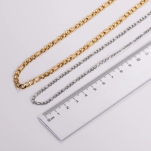 Detail view of gold and silver stainless steel Figaro chain necklaces with measuring ruler