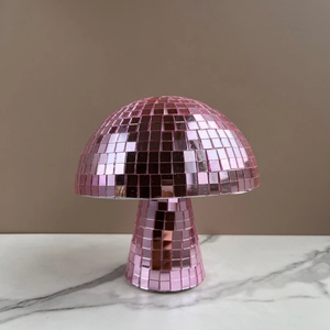 Pink mushroom disco ball decor with mirrored tiles on marble surface