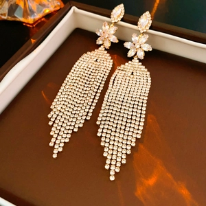 Close-up of golden flower stud earrings with cascading zircon tassel fringe detail