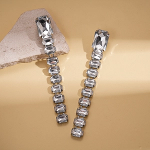 Elegant rectangle crystal tassel drop earrings on stone podium in natural light