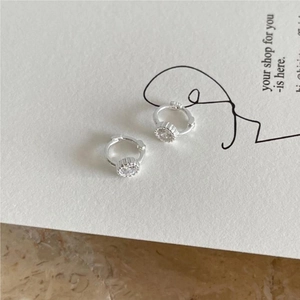 Detail of silver stud earrings with clear cubic zirconia on a minimalist white card