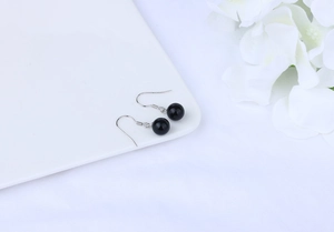 Detail of S925 sterling silver hooks with black agate beads on white porcelain