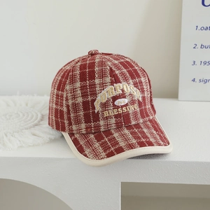 Detail of red and beige plaid wool baseball cap with Purpose embroidery on a stand