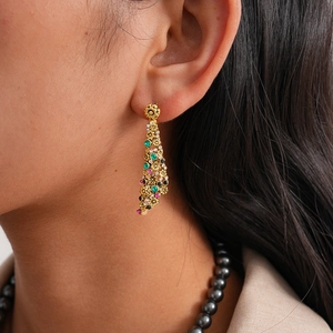 Macro detail of vintage gold hollow flower earring with vibrant colorful rhinestones