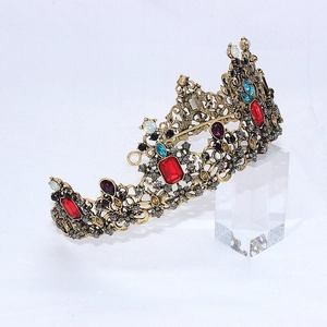 Détail d'une couronne dorée vintage avec cristaux colorés et motifs floraux en métal