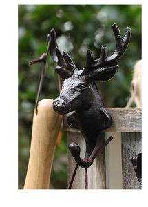 Macro shot of vintage cast iron deer head wall hook on rustic wooden texture background