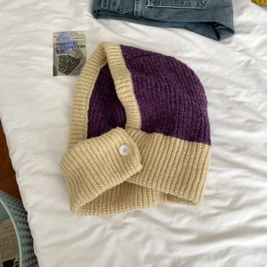 Detail of purple and beige knitted balaclava with chunky wool texture and button closure