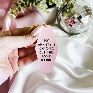 Retro pink hotel-style keychain with funny quote and golden ring on silk background
