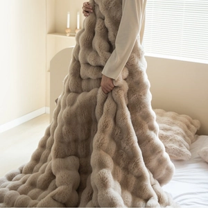 Plush faux rabbit fur blanket in light brown with textured wave pattern and soft touch