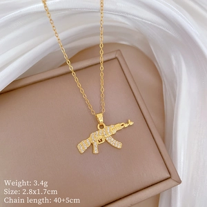 Detail view of a gold AK-47 pendant necklace with rhinestones and product dimensions