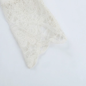 Close-up of elegant white lace detailing and intricate floral embroidery on the sleeve cuff