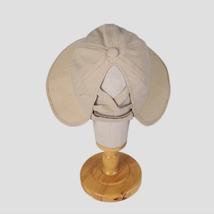 Detail of beige sun hat featuring breathable linen fabric and ponytail cross elastic band