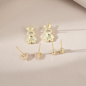 Three-pair gold earring set featuring crystal bunny, pink heart, and floral designs