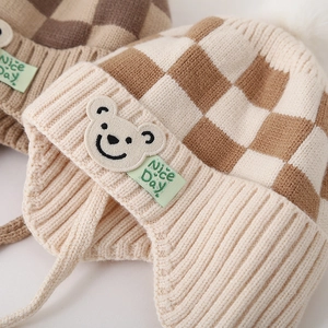 Gebreide babymuts met ruitpatroon, beer-patch en oorkleppen voor de winter