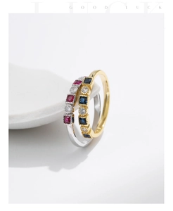 Detail of vintage stackable S925 silver rings with square gemstones in gold and silver